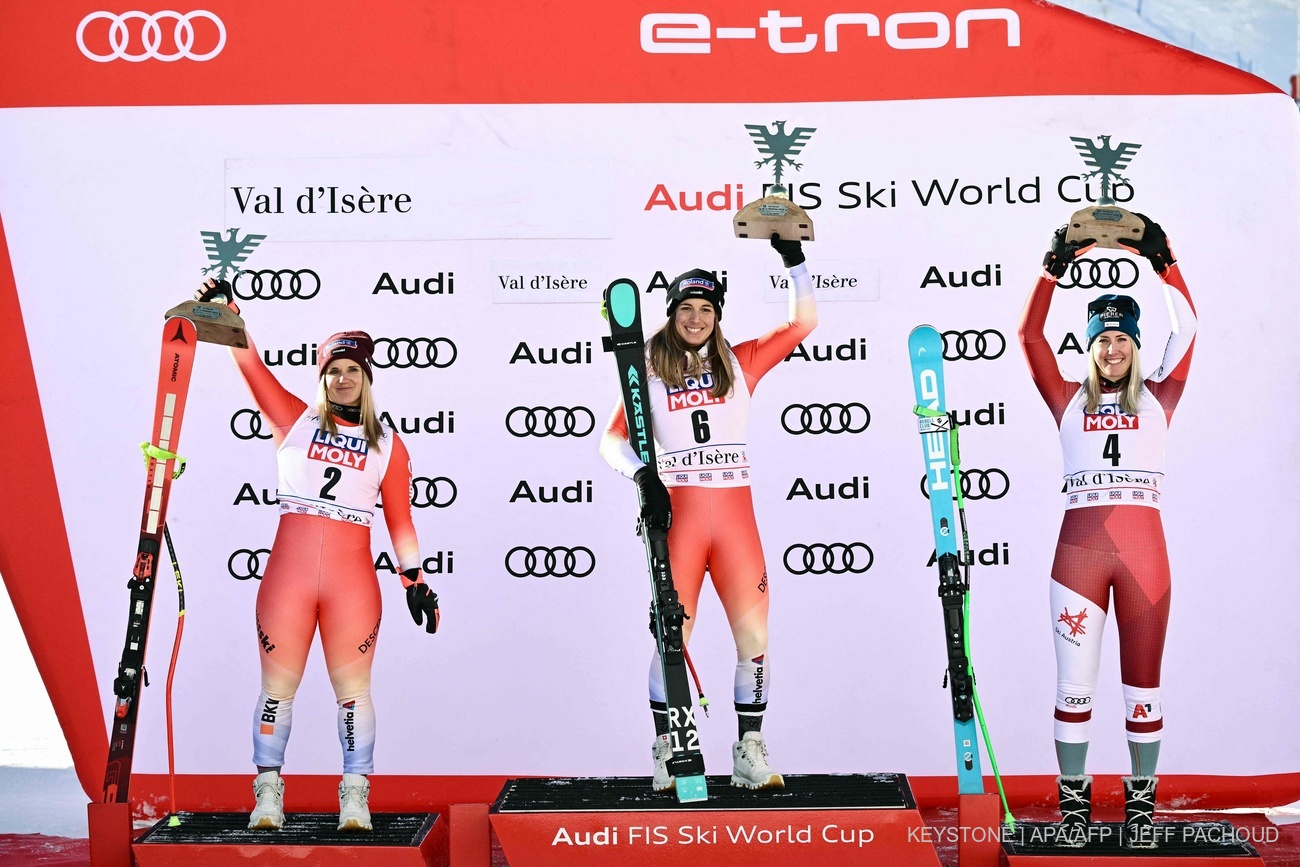 ABD0076_20231216 - VAL-D'IS"RE - FRANCE: First-placed Switzerland's Jasmine Flury (C) celebrates her victory on the podium flanked by second-placed Switzerland's Joana Haehlen (L) and third-placed Austria's Cornelia Huetter (R) after the Women's Downhill race at the FIS Alpine Skiing World Cup event in Val-d'Isere, in the French Alps, on December 16, 2023. (Photo by Jeff PACHOUD / AFP). - FOTO: APA/AFP/JEFF PACHOUD